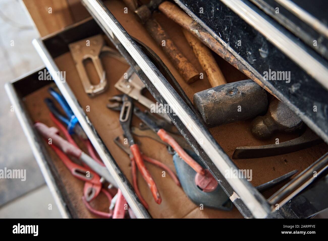 Hämmer und Werkzeuge in offenen Schubladen einer Werkbank Stockfoto