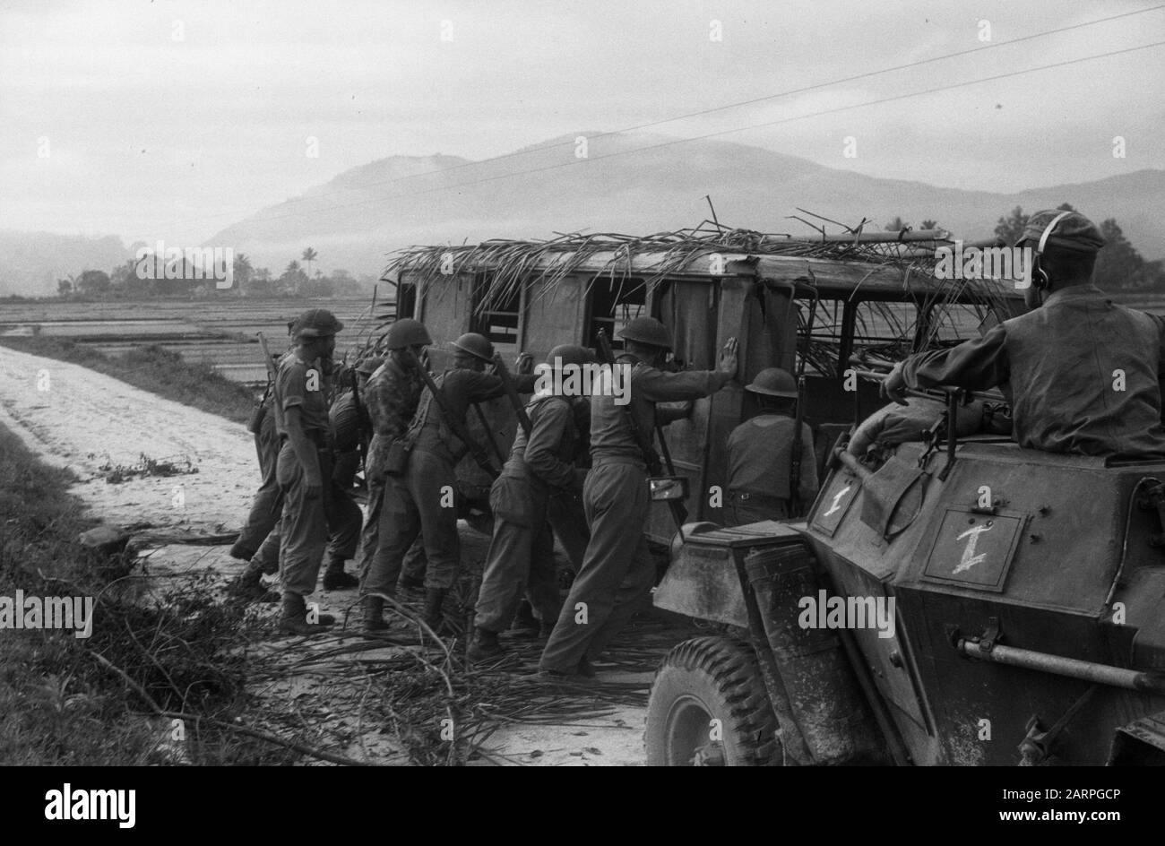 Balsy, Taroetoeng, Si Borong-Brong und auf dem Weg nach Padang Sidempoean [2. Polizeiaktion, Aktionen Hahn, Duck und Pigeon] [EIN Autobus ohne Reifen und Palmen auf dem Dach, niederländische Infantrymen, die das Hindernis aufsetzen] Datum: 1948/12/30 Ort: Indonesien, Niederländische Ostindien, Sumatra Stockfoto