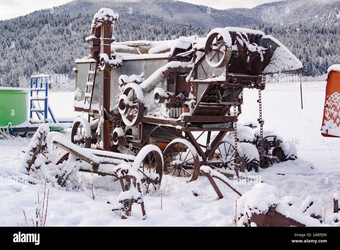 Alte, schneebedeckte Mähdrescher und andere Anbaugeräte auf einer abgelegenen Pferdefarm in Beavertail, Montana. Beavertail liegt östlich von Clinton, in Granit C Stockfoto