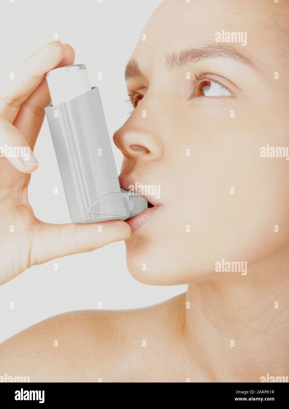 Junge Frau mit Asthma Inhalator auf weißem Hintergrund Stockfoto