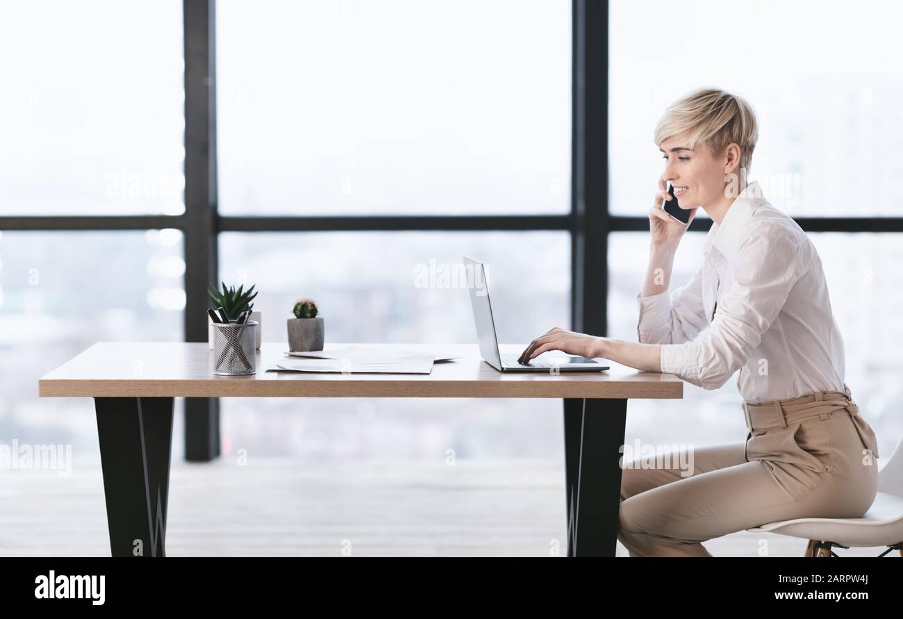 Geschäftsfrau Telefonieren Mit Laptop Im Büro, Seitenansicht Stockfoto