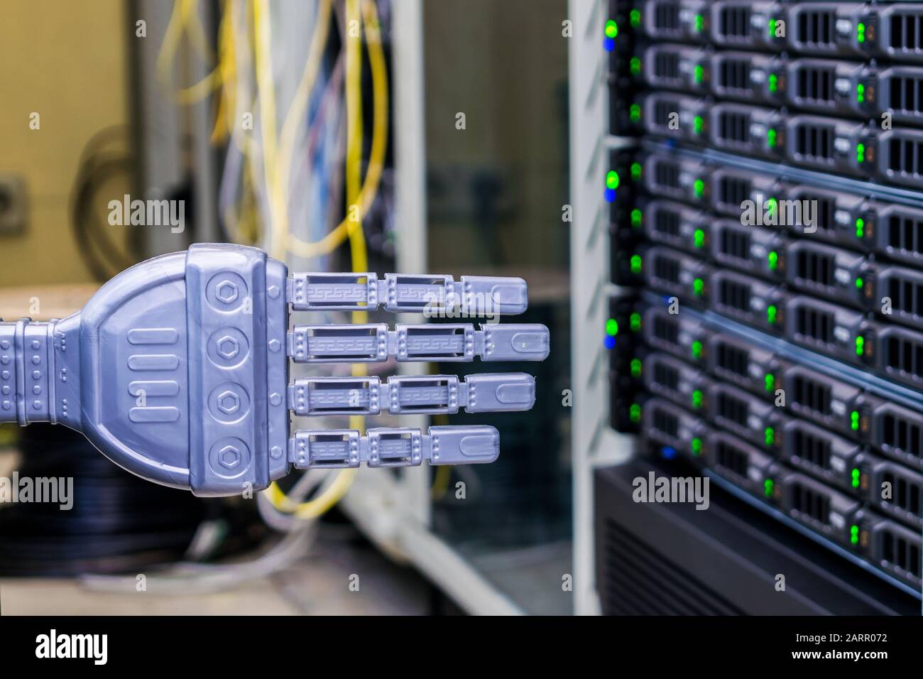 Die Hand des Roboters befindet sich im Serverraum des Rechenzentrums. Das Konzept der Robotersteuerung von Computersystemen. Stockfoto