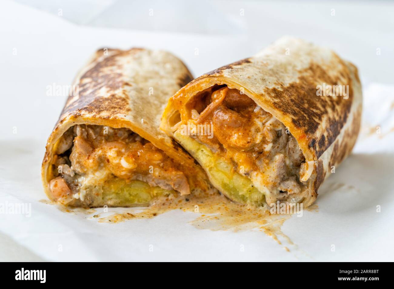 Mexikanischer Wrap Burrito mit Steakfilet, Guacamolesauce, Sauerkreme, Pico De Gallo, Mozzarella-Käse und Kartoffeln/kalifornischer Stil. Fast Food. Stockfoto