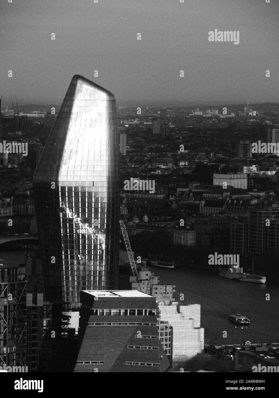 Ein bildernes Schwarzweiß-Bild von Sonnenlicht, das von einem hochmodernen Wolkenkratzer in London reflektiert wird Stockfoto