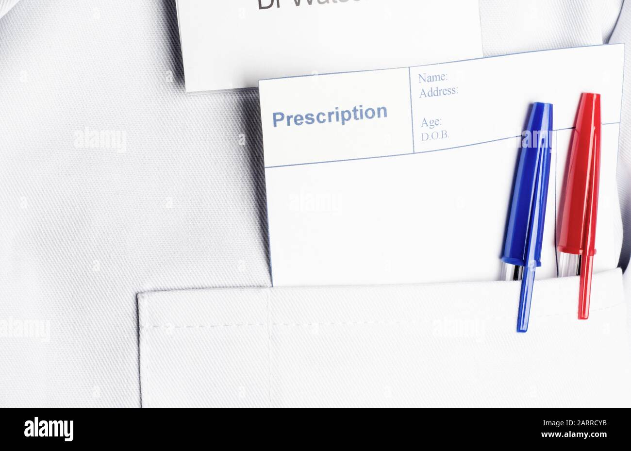 Ein leeres Rezept und zwei Stifte, die aus der weißen Jackentasche Eines Arztes stochern und so Platz für eine Nachricht bieten. Stockfoto