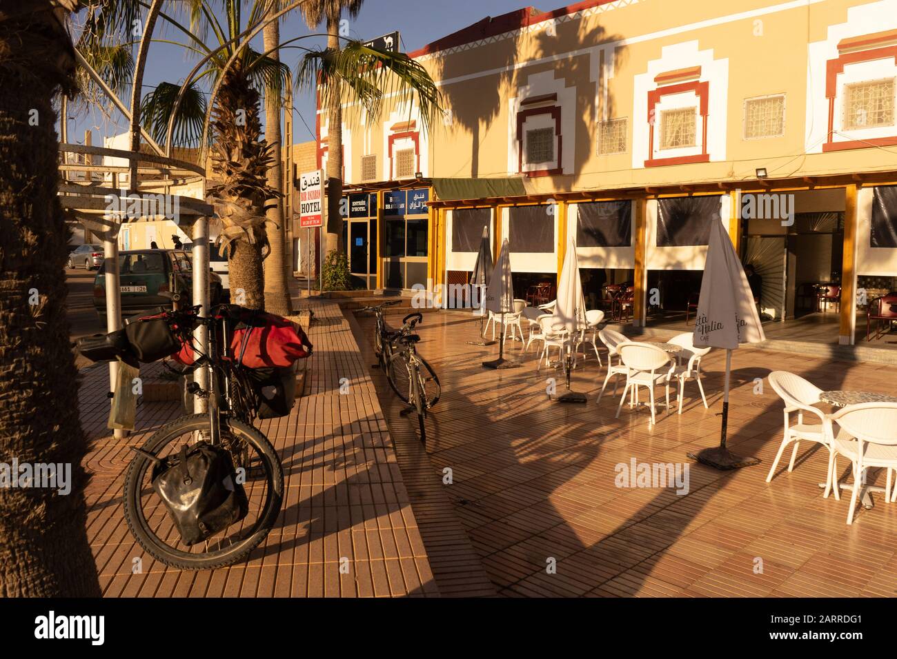 Ein Tourfahrrad, das sich gegen einen Pfosten vor dem Restaurant in Tan Tan, Marokko neigt Stockfoto