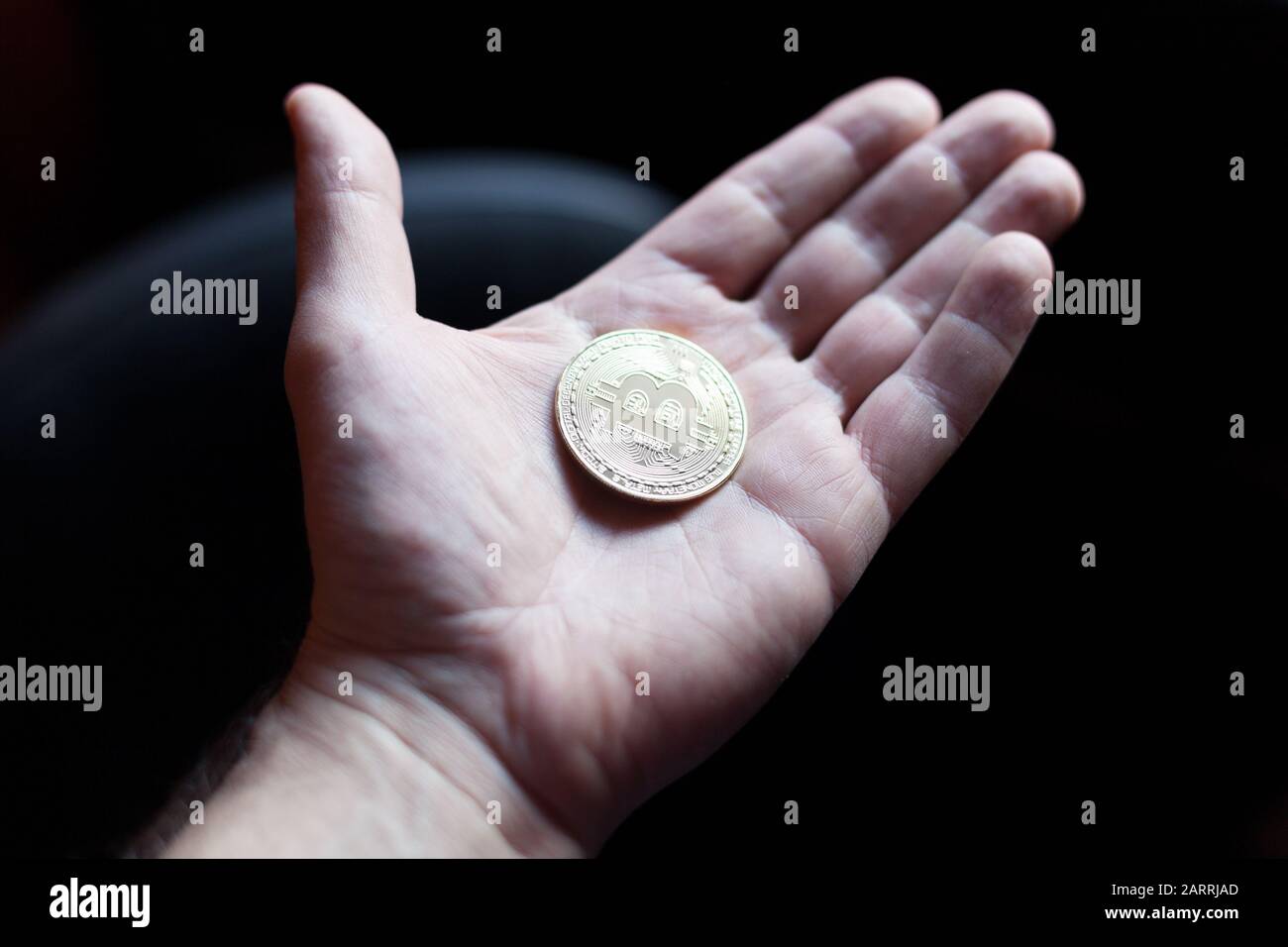 Halten einer Bitcoin-Kryptokurrency in der Hand Stockfoto