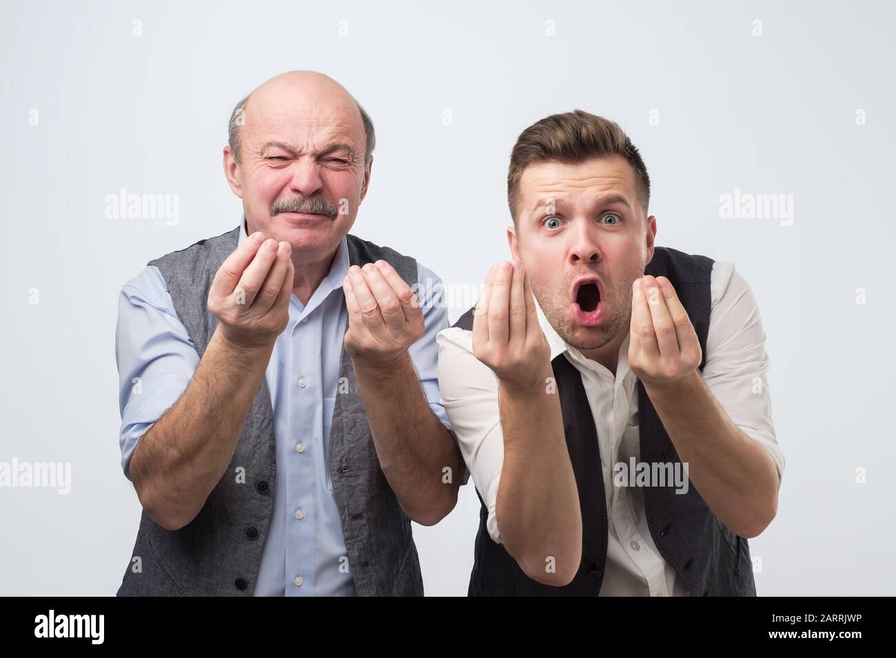 Zwei reife Männer, die mit dem Finger zeigen, während sie mit ihrem Gegner streiten. Vater und Sohn sind mit Argumenten nicht einverstanden. Stockfoto