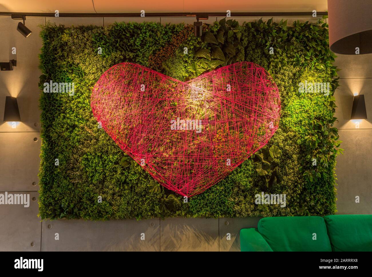Romantisches Interieur im Café mit grünen Wohnwänden und Herz Stockfoto