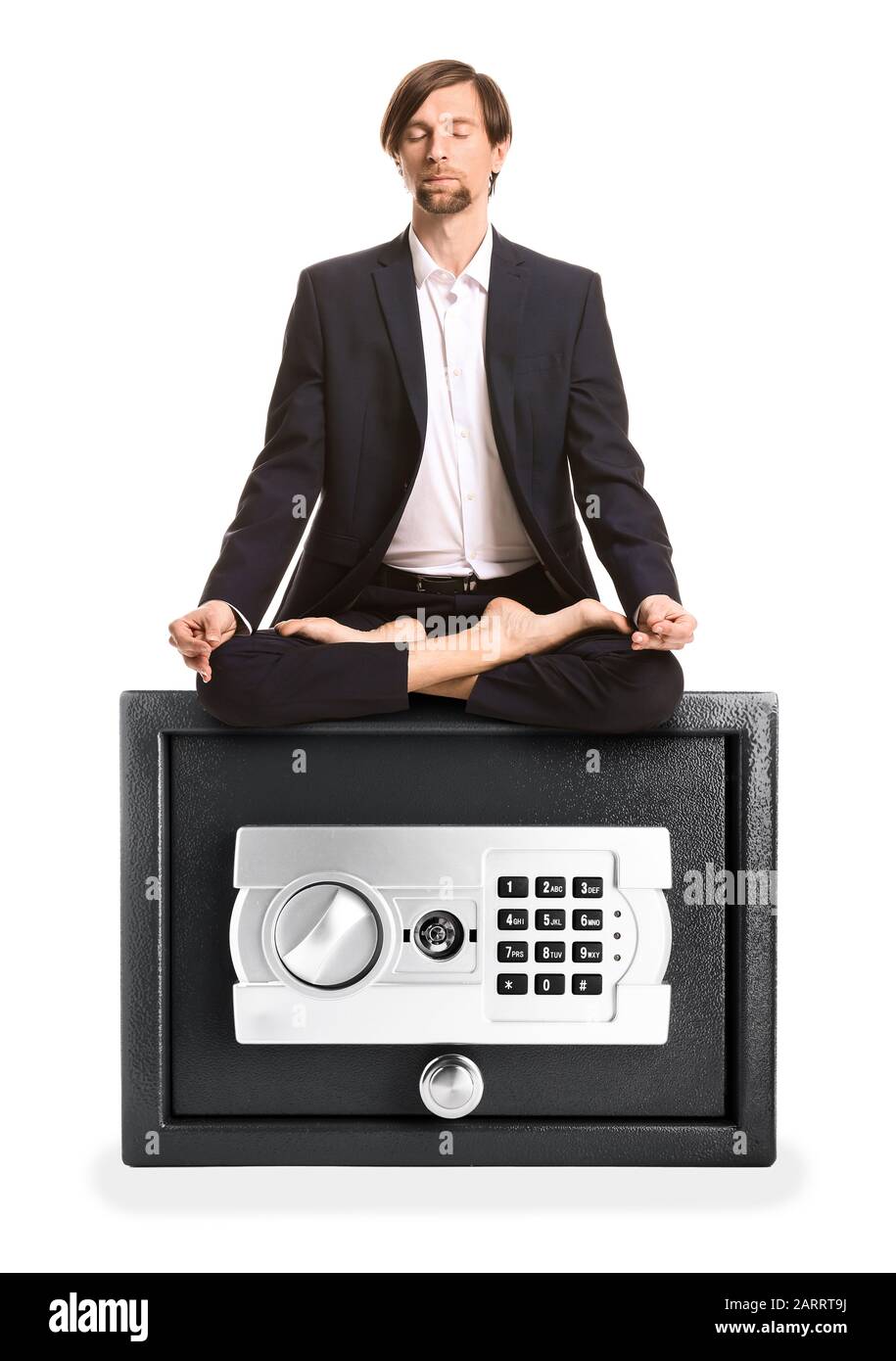 Meditierender Geschäftsmann sitzt auf einem Safe vor weißem Hintergrund Stockfoto