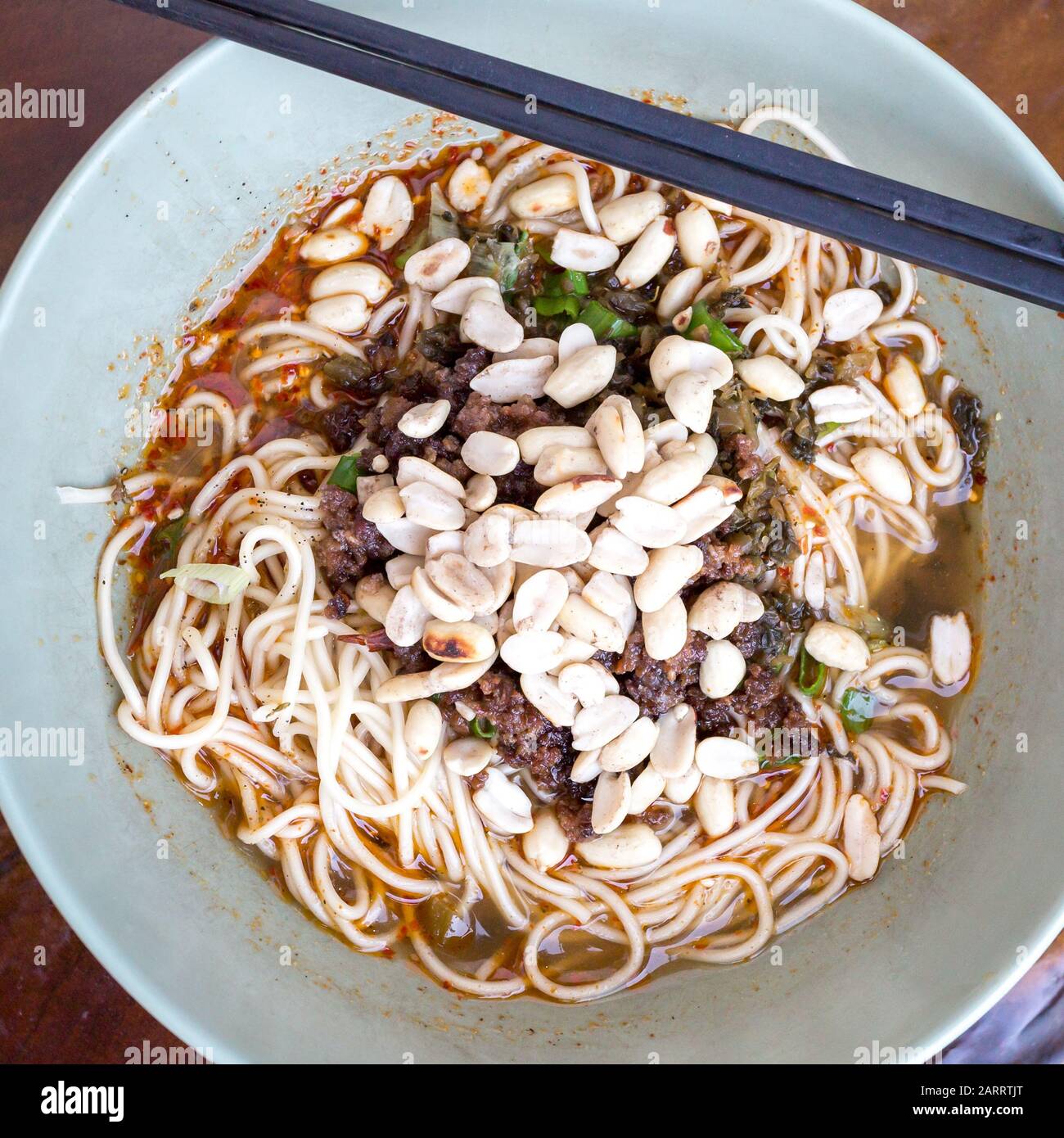 Nahansicht des Tellers mit Nudeln im Sichuan-Stil wie würzige Nudeln mit Hühnergizzard, Hackfleisch, Gemüse und Erdnuss, chinesische Küche Stockfoto