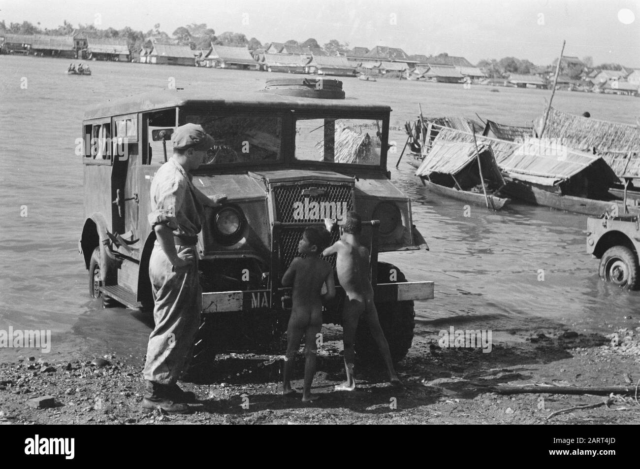 Palembang-Soldat K. Hukshoorn aus Lienden, Fahrer 4-7 R.I, ließ Padang sein Auto waschen. Er legt das Auto teilweise in die Moesi und Heimatjungen helfen ihm gerne mit einem Stück Brot und einigen Zigaretten. Die schnellen Jungen können überall leicht zugänglich sein, und ihre Kleidung wird nicht schmutzig oder nass, da sie sich so lange wie am Ufer ablagern Datum: Juli 1947 Ort: Indonesien, Niederländische Ostindien, Palembangs, Sumatra Stockfoto