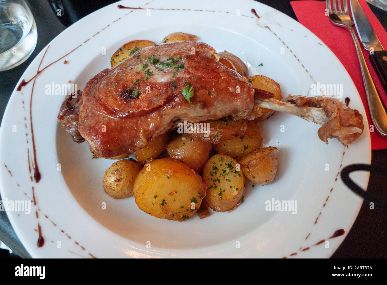 Das auf einem Bett mit neuen Kartoffeln servierte Entenconfit ist eine französische kulinarische Spezialität in Paris, Frankreich. Stockfoto