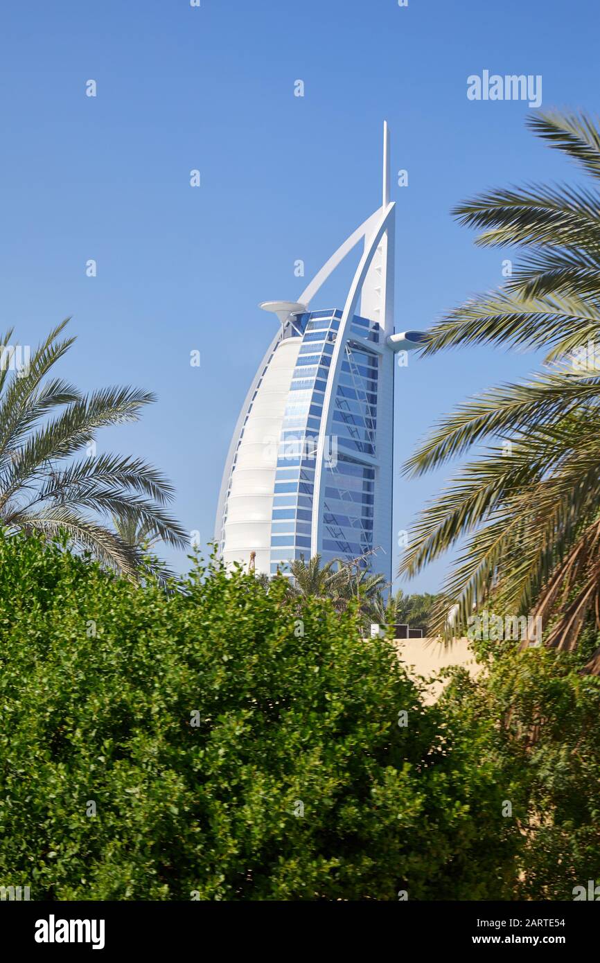 Dubai, VEREINIGTE ARABISCHE EMIRATE - 22. NOVEMBER 2019: Luxushotel Burj Al Arab mit Palmen an einem sonnigen Tag, blauer Himmel in Dubai Stockfoto