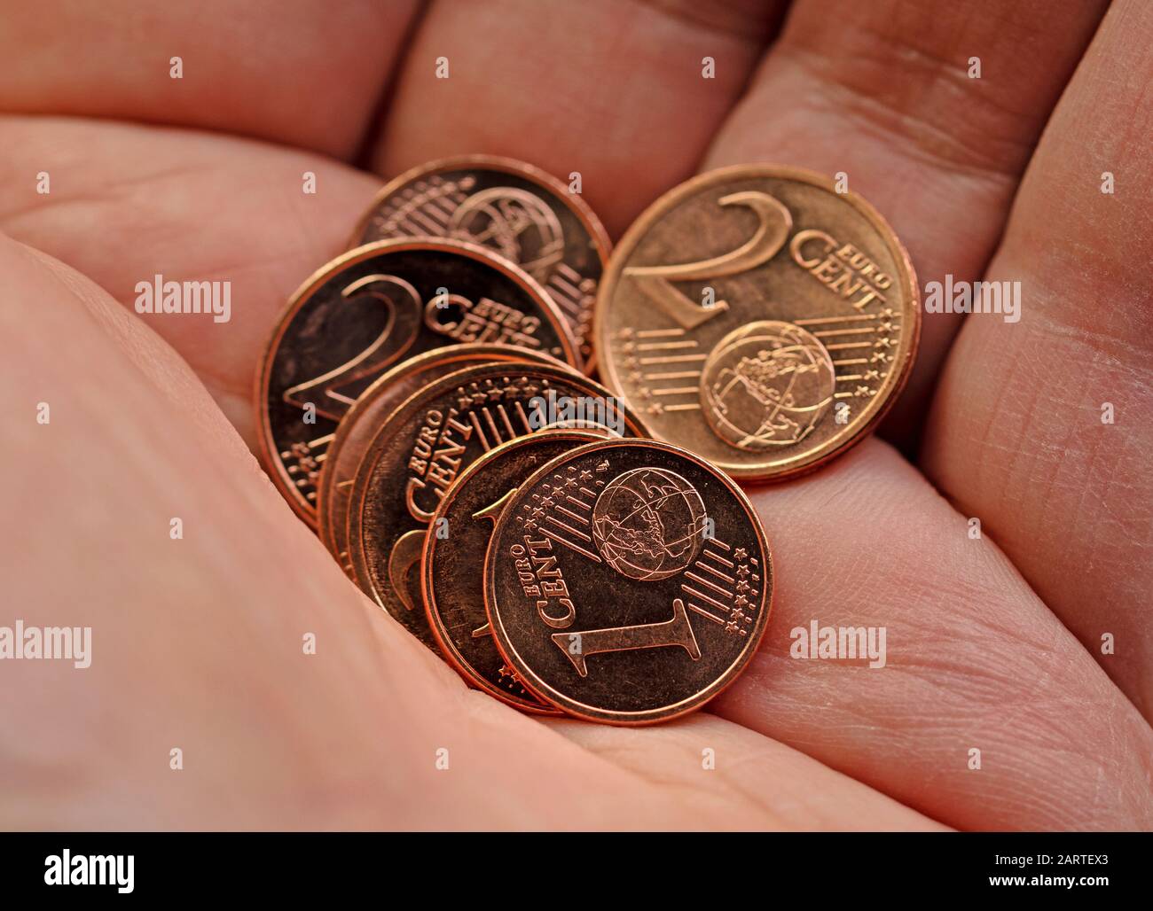 Kleine Euro-Cent-Münzen in der Hand Stockfoto