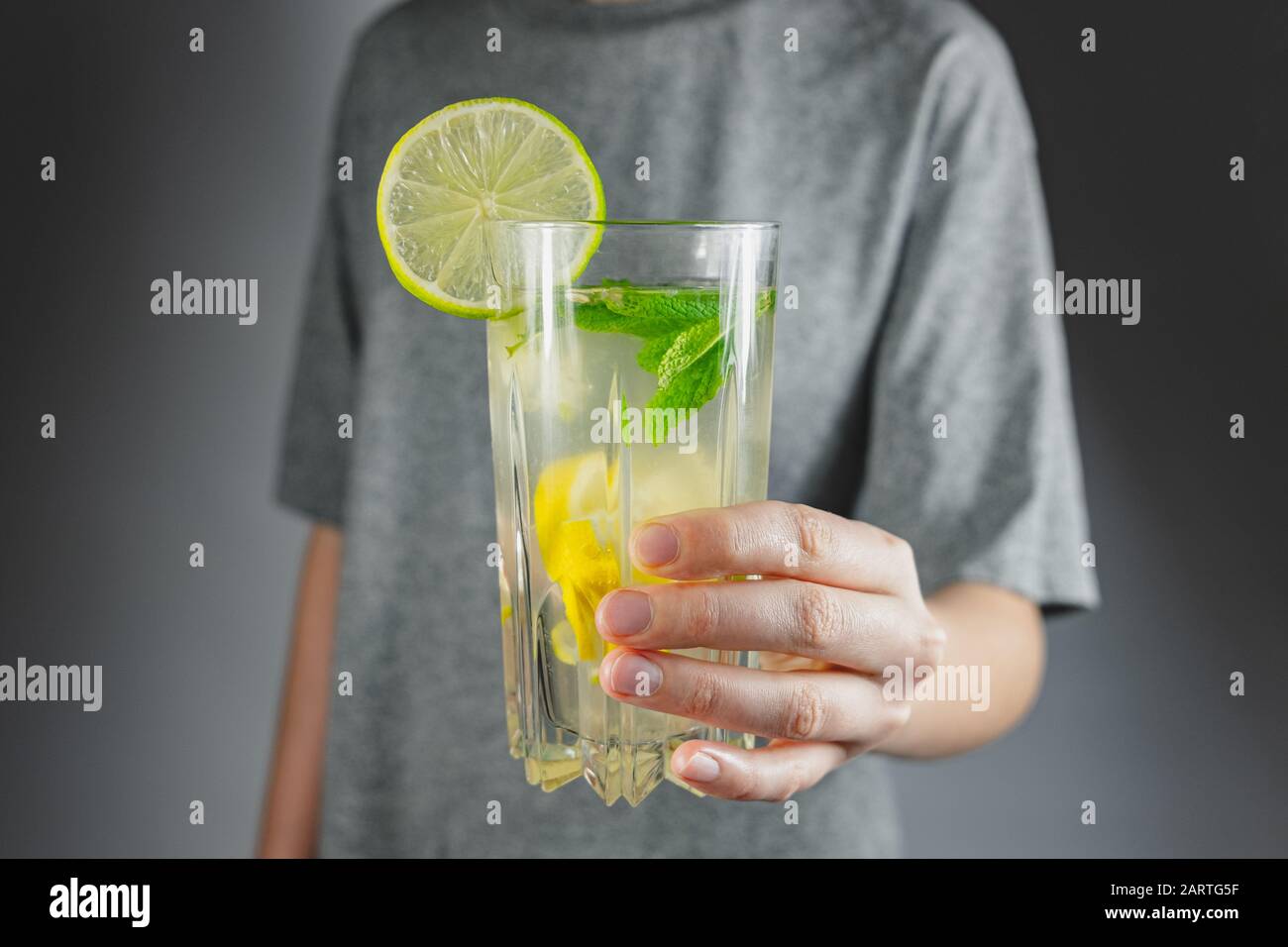 Glas Zitronengetränk in einer menschlichen Hand. Kater heilen, Tonic Wasser oder Mojito Erfrischung Stockfoto
