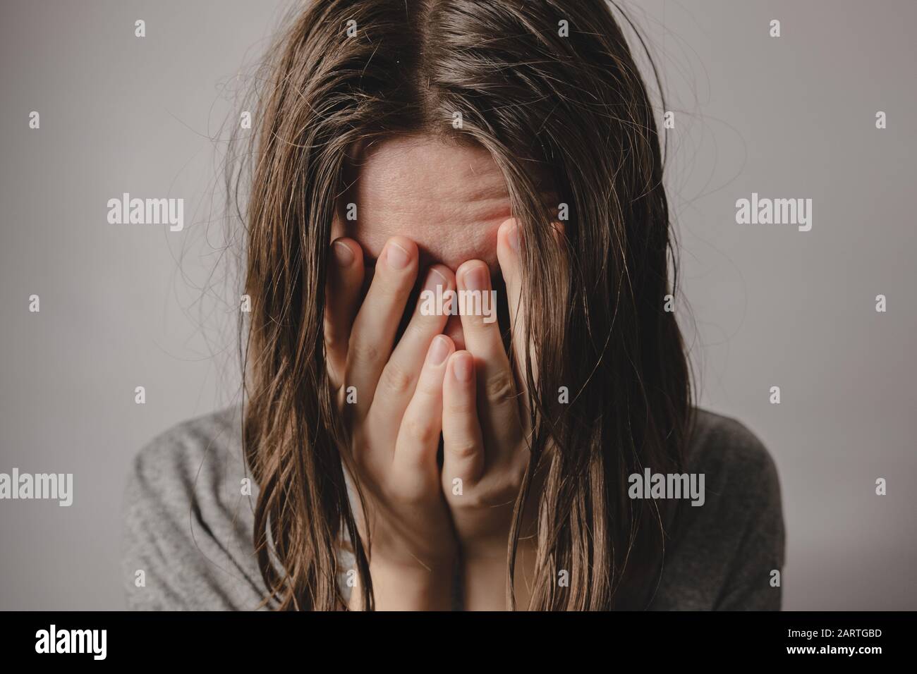 Frau bedeckt Gesicht in den Händen. Konzept der Verzweiflung, Depression, Verlust oder psychischen Verfassung Stockfoto