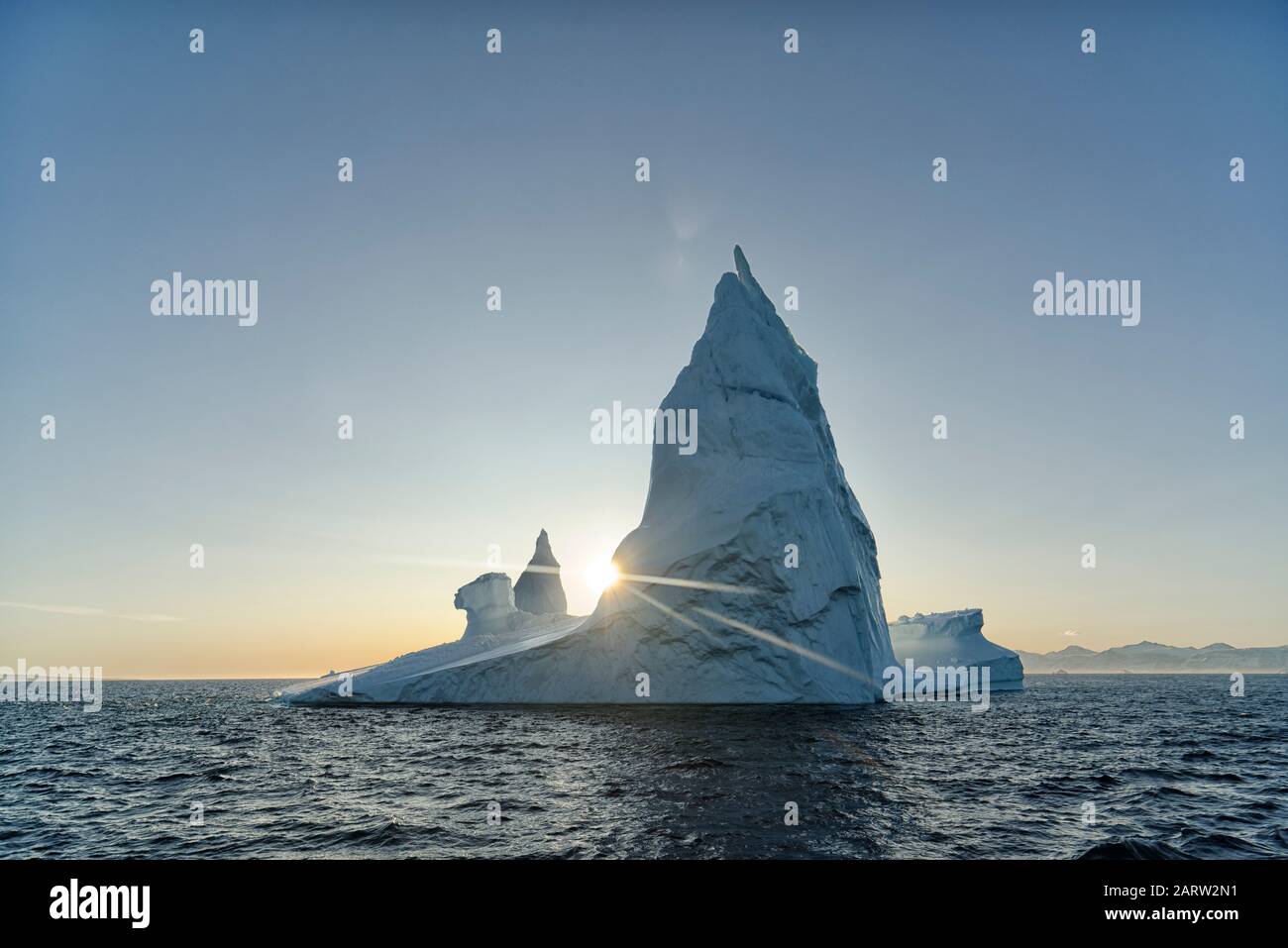 Sonne hinter einem markanten Eisberg. Scoresby Sund. Kangertittivaq, Grönland, Dänemark Stockfoto