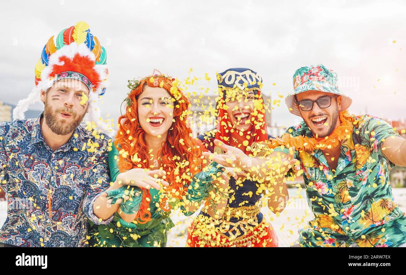 Fröhliche Freunde feiern auf der brasilianischen Karnevalsparty - Junge Leute, die Karnevalskostüme tragen, haben Spaß daran, Konfetti zu werfen und gemeinsam zu lachen Stockfoto
