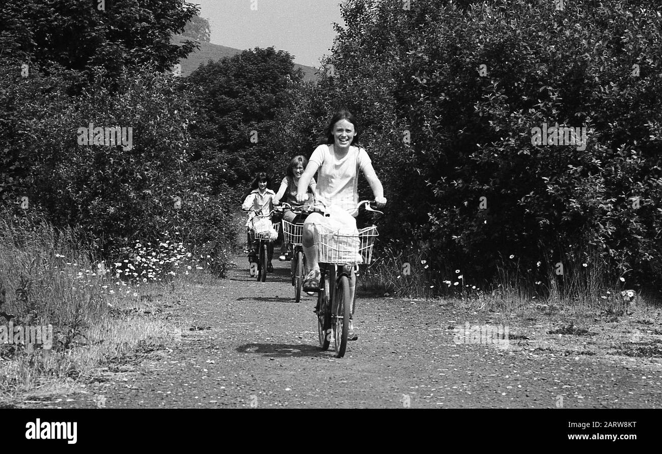 1970er Jahre, historisch, eine Mutter und ihre Kinder unterwegs auf einer Tagesradfahrt mit der Familie, die auf einem Weg durch ein Waldgebiet, England, Großbritannien, geht. Stockfoto