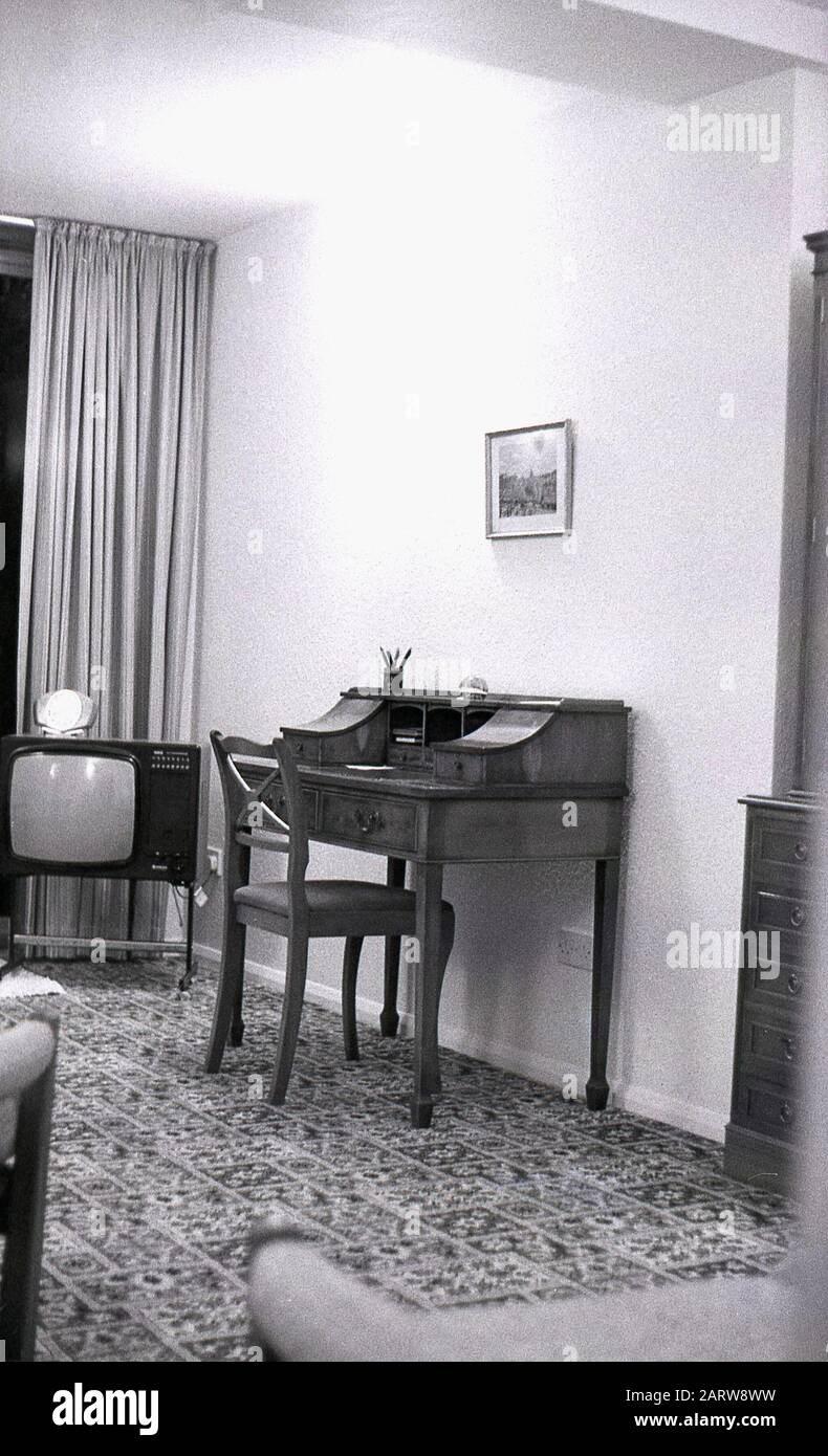 1970er Jahre, historische Innenansicht eines Loungebereichs eines Hauses mit einem antiken Schreibtisch und Fernseher der Epoche, England, Großbritannien. Stockfoto