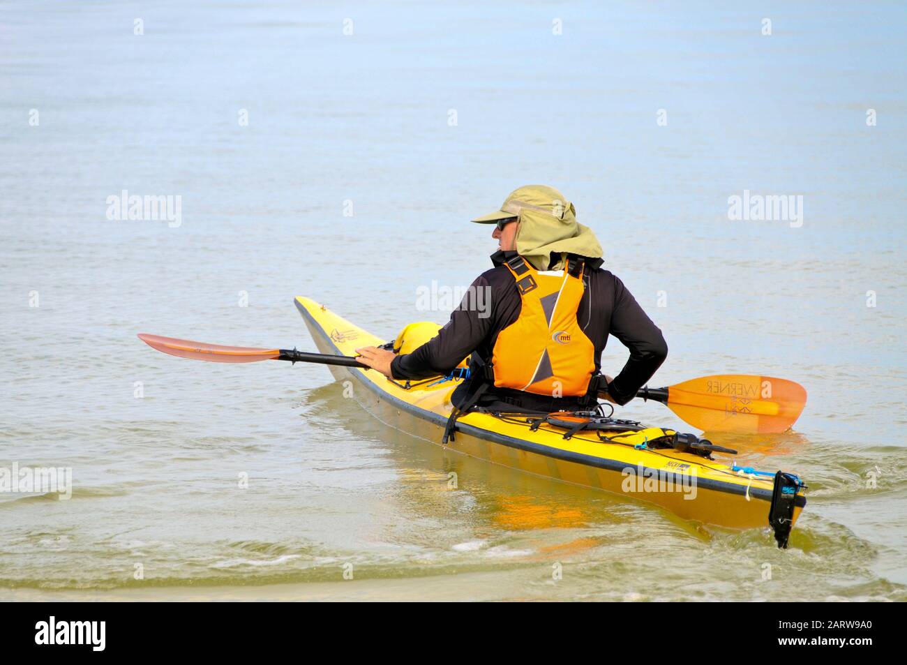 Holmes BEACH ANNA MARIA ISLAND, FL - 21. September 2012: Mann rudert mit seinem Kajak, während er vom Strand von Anna Maria Island, F, in den ruhigen Ozean lauert Stockfoto