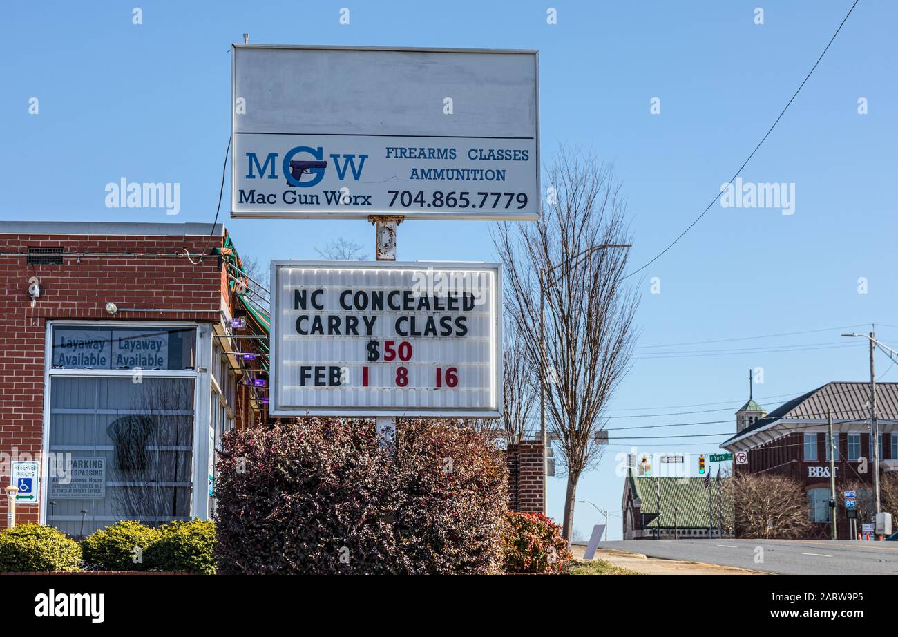 Gastonia, NC, USA-26 JAN 2020: Ein Feuerwaffen- und Trainingsspeicher mit Schildern, die eine NC-verborgene Carry-Klasse werben. MGW, Mac Gun Worx verkauft Schusswaffen und A. Stockfoto