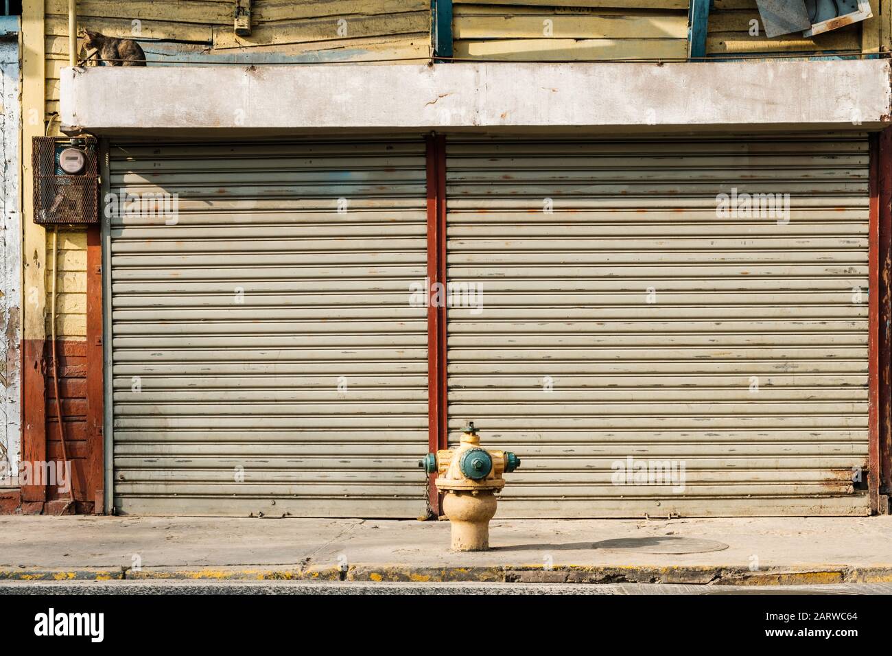 Außenansicht mit geschlossenen Fensterläden, zum Laden auf der Straße, Gehweg und Hydrant - Stockfoto