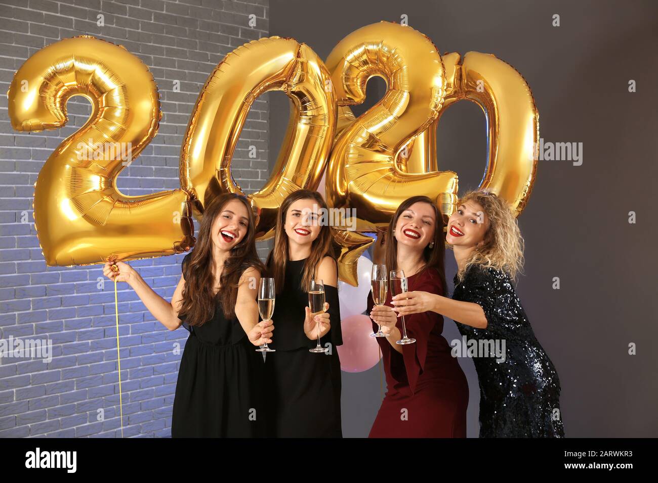 Schöne junge Frauen, die auf der Weihnachtsfeier Champagner trinken Stockfoto