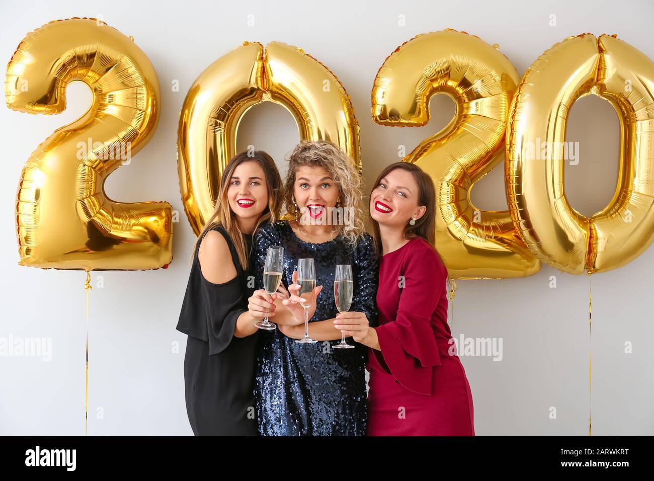 Schöne junge Frauen, die auf der Weihnachtsfeier Champagner trinken Stockfoto