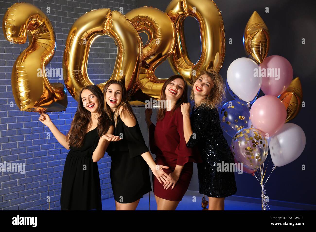 Schöne junge Frauen mit Ballons bei der Weihnachtsfeier Stockfoto