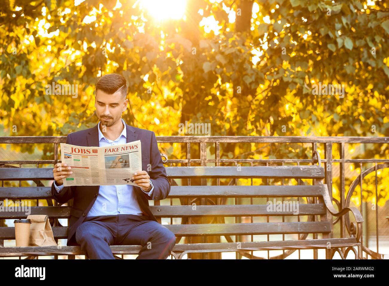 Porträt eines gutaussehenden Geschäftsmannes, der die Zeitung im Freien liest Stockfoto