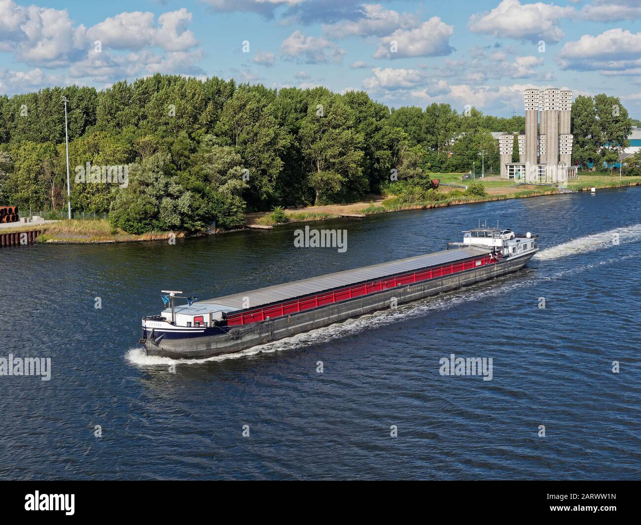 Die Cetera, ein niederländischer River Barge, der den Nordseekanal entlang der Velsertunnel-Belüftungstürme an der Nordbank führt. Stockfoto