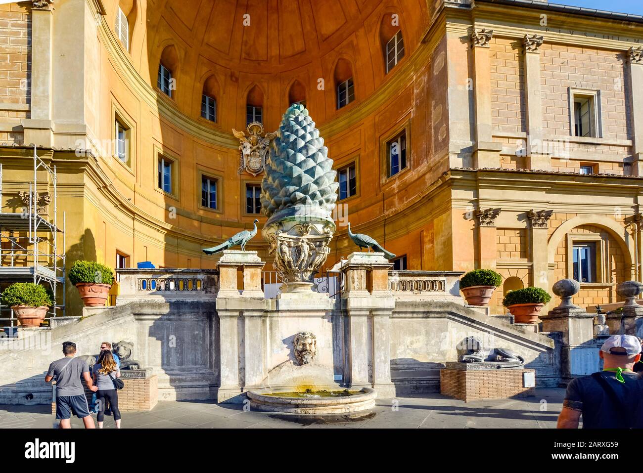 Touristen besuchen die Fontana della Pigna, einen ehemaligen römischen Brunnen, der jetzt eine Nische in der Wand des Vatikans in der Vatikanstadt, Rom, schmückt Stockfoto