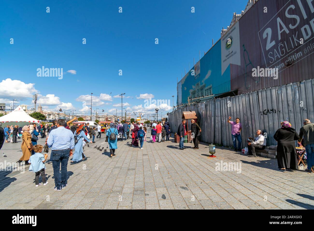 Lokale Türken versammeln sich an einem sonnigen Sommertag in der Nähe der Galata-Brücke in Istanbul, Türkei, auf einem belebten Platz. Stockfoto