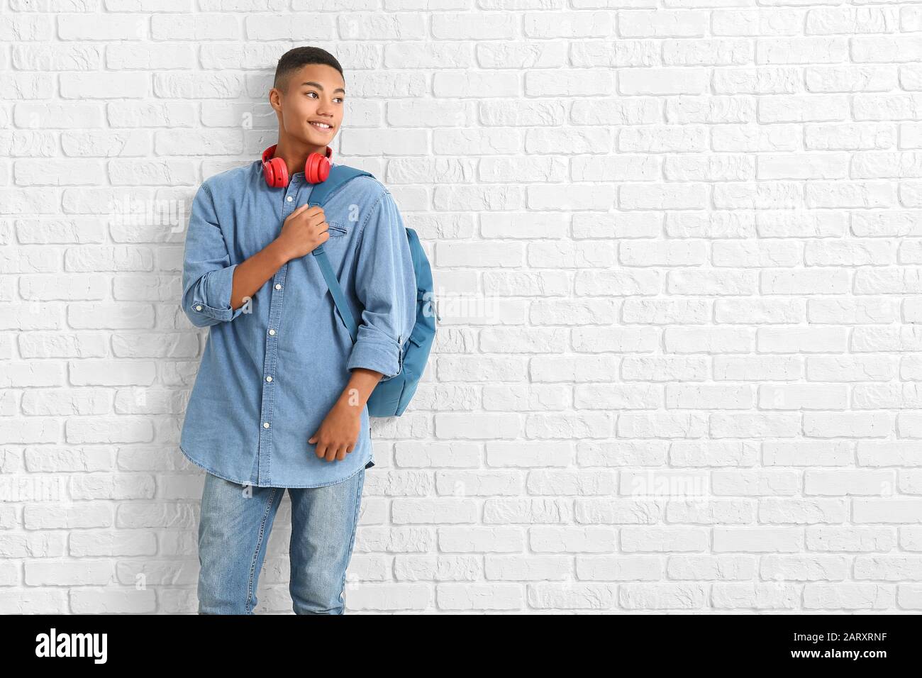 Porträt eines afroamerikanischen Teenager-Schuljungen auf Backstein-Hintergrund Stockfoto