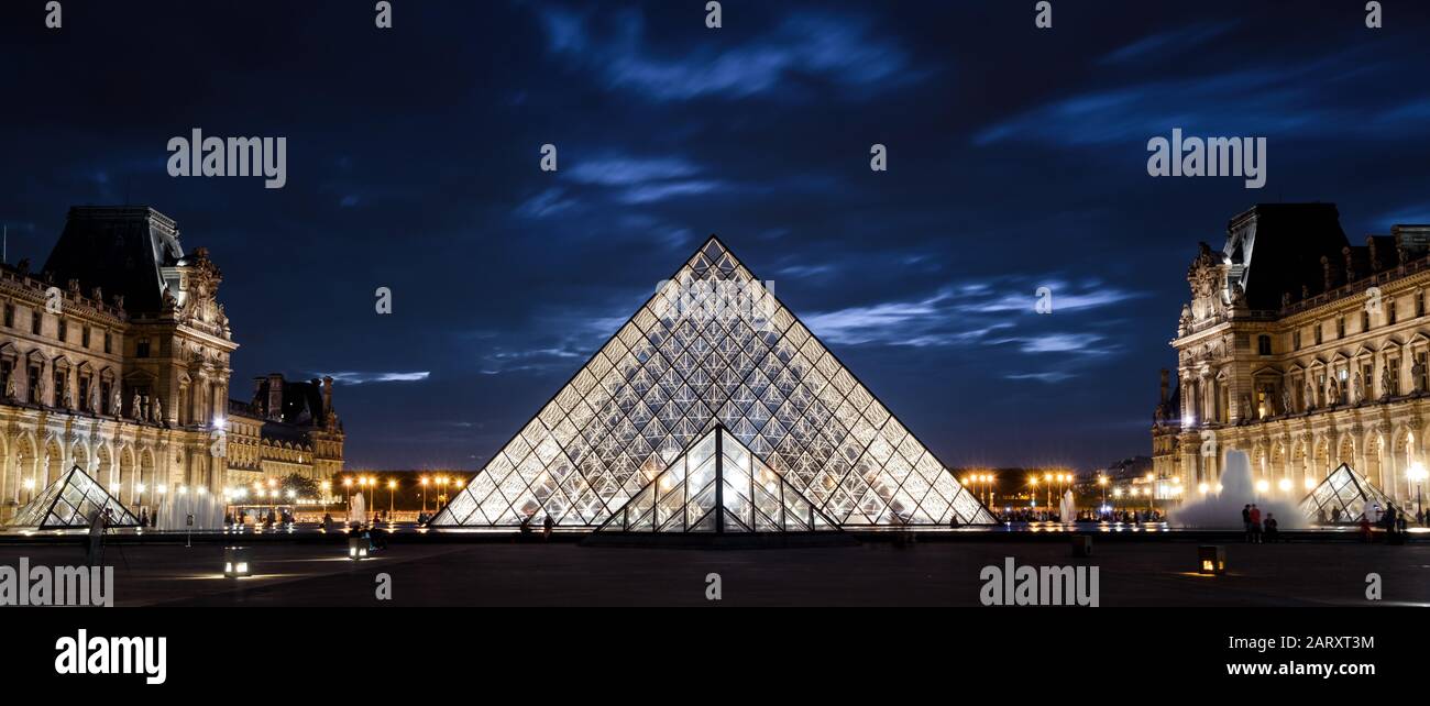 Paris - 25. September 2013: Louvre in der Nacht in Paris. Der berühmte Louvre ist eines der beliebtesten Reiseziele in Frankreich. Panoramablick auf den Louvre und das Glas Stockfoto