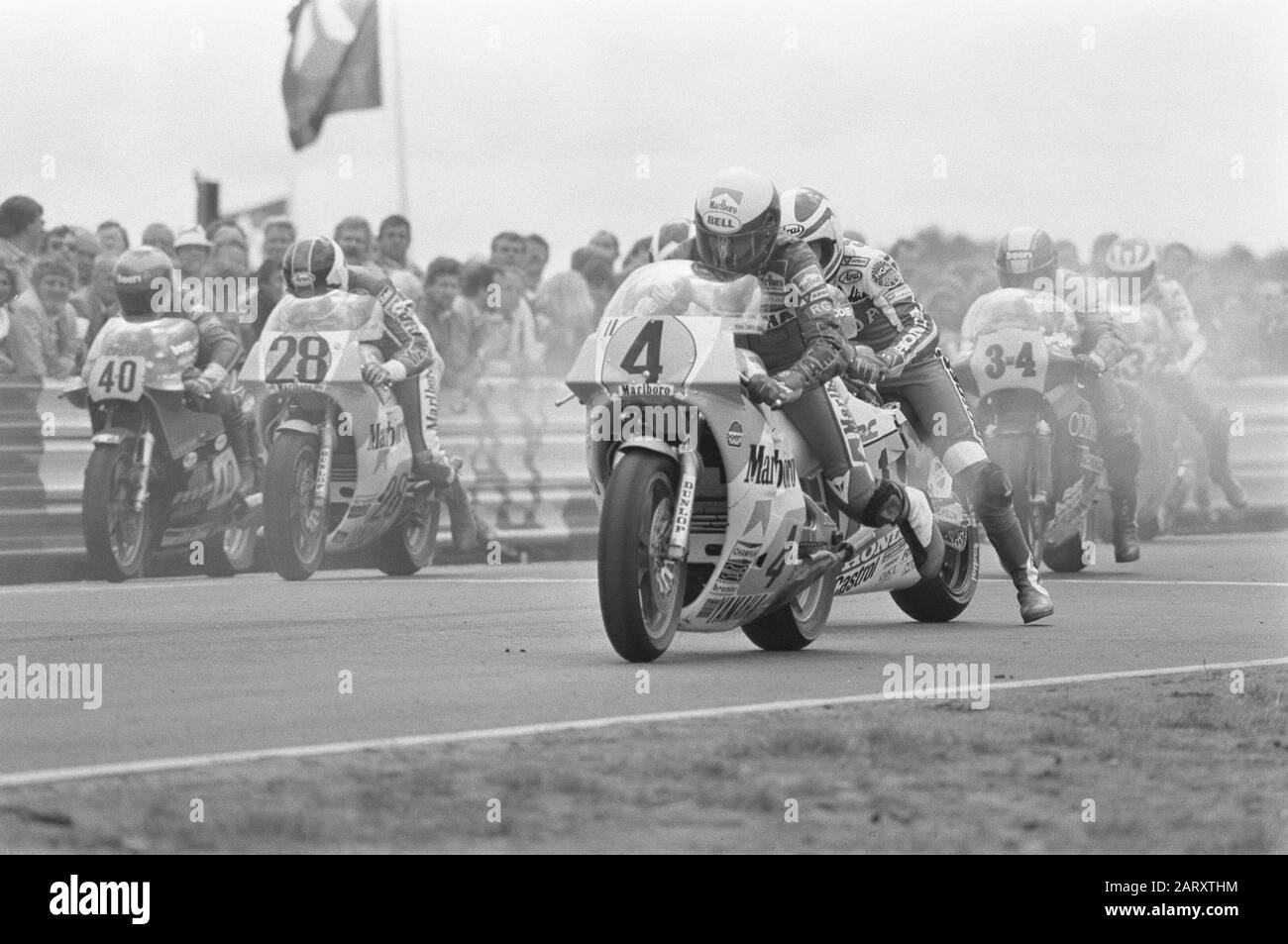 TT Assen 1984 TT van Assen, 500-cc-Rennen. Beginn der Königsklasse. Kenny Roberts (4) verlässt die Pole-Position, direkt hinter ihm (versteckt) Kenny Lawson Datum: 30. Juni 1984 Ort: Axis Keywords: Motorradfahrer, Motorräder, Motorradrennen, Name der Sportperson: Lawson, Kenny, Roberts, Kenny Institution Name: TT Stockfoto