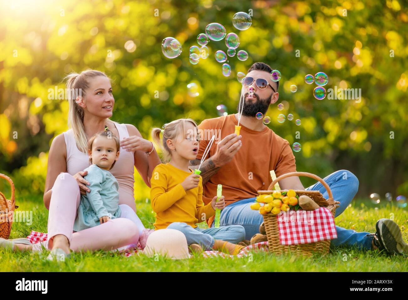 Glückliche Familie, die an einem Sommertag im Park Picknick macht.Glücks-, Familien- und Urlaubskonzept. Stockfoto