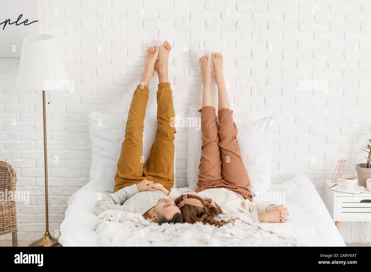 Schönes junges Paar, das zu Hause auf dem Bett liegt Stockfoto