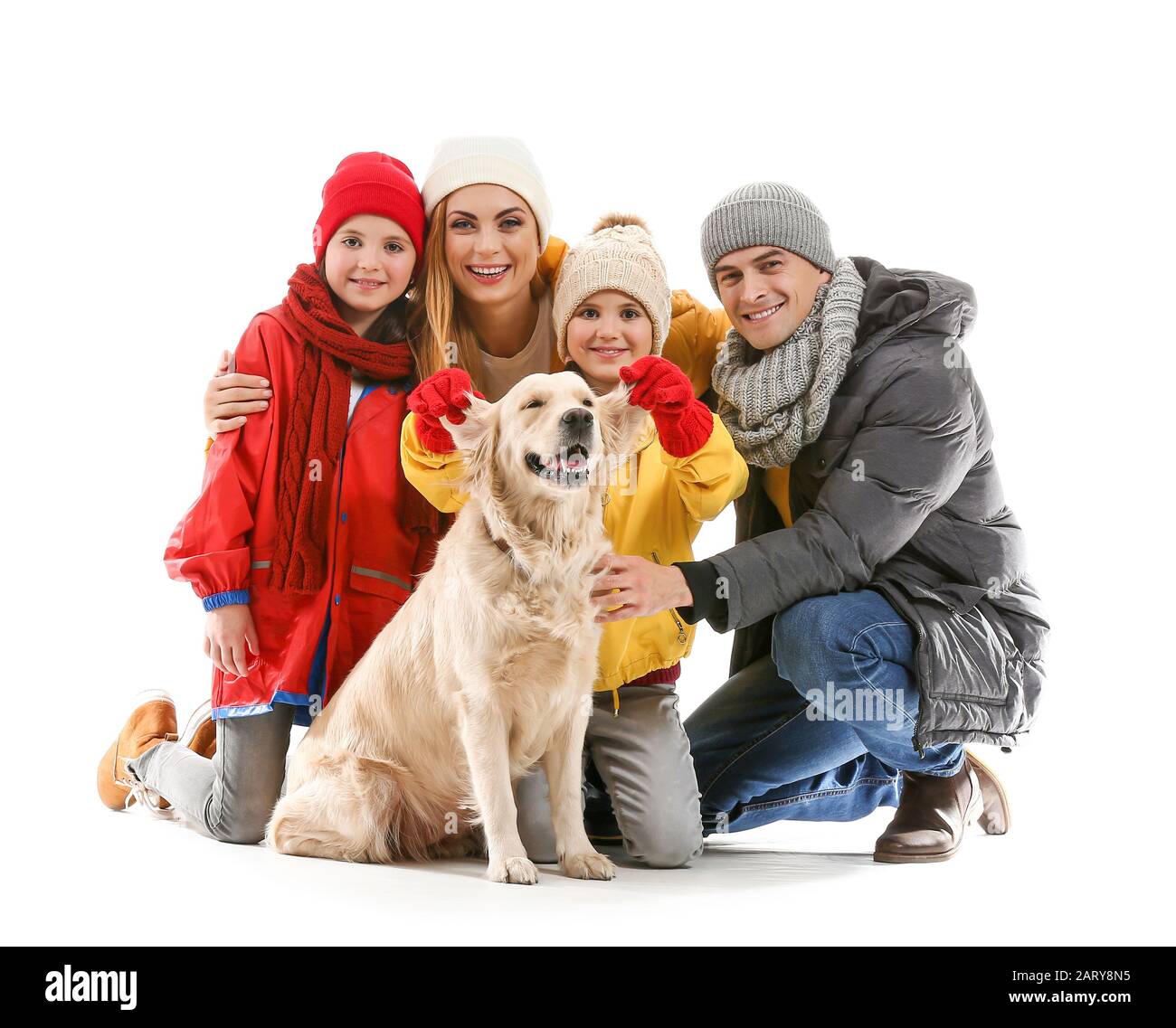 Glückliche Familie in Herbstkleidung und mit Hund auf weißem Hintergrund Stockfoto