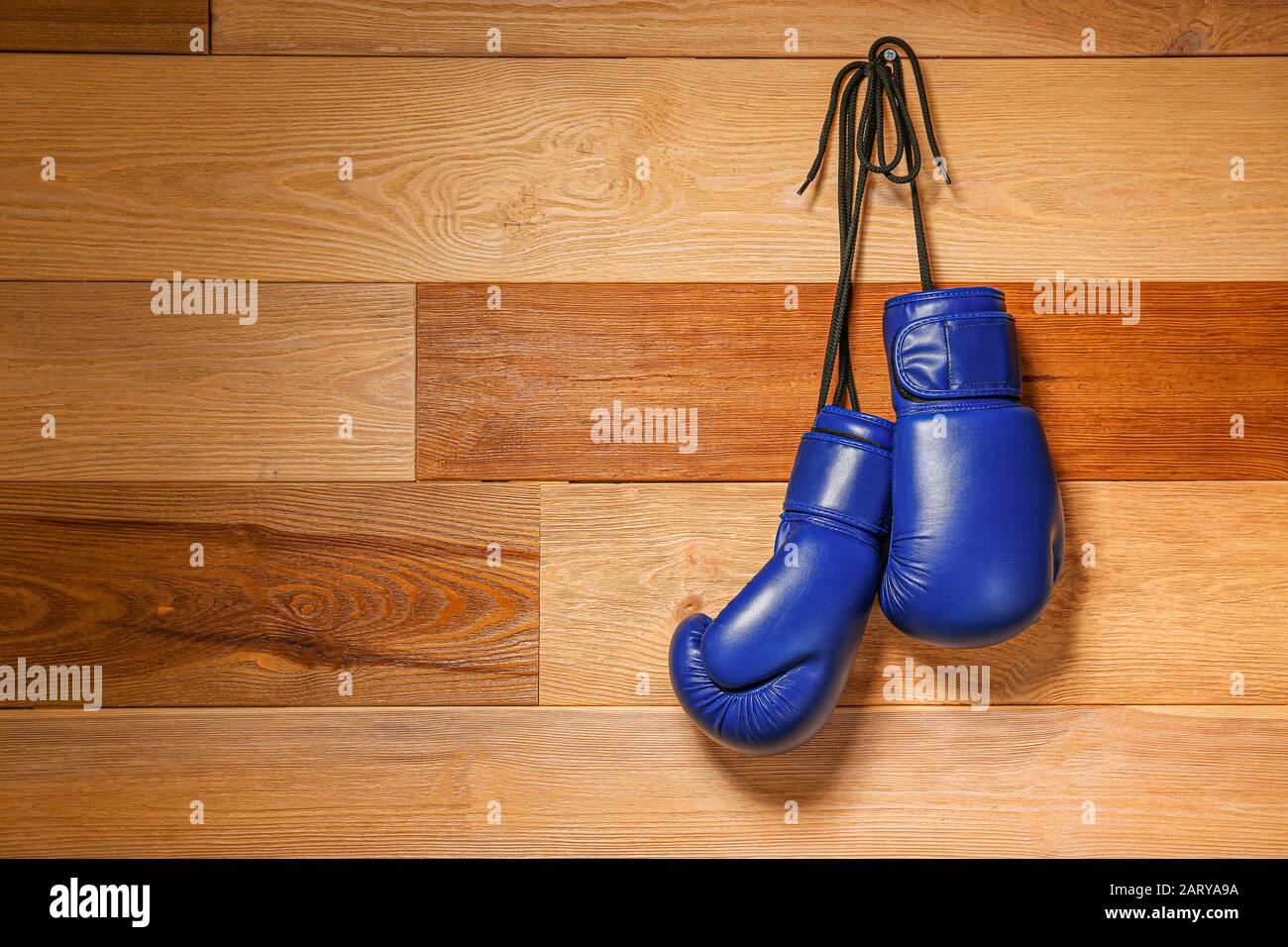 Zwei Boxhandschuhe hängen an der Holzwand Stockfoto