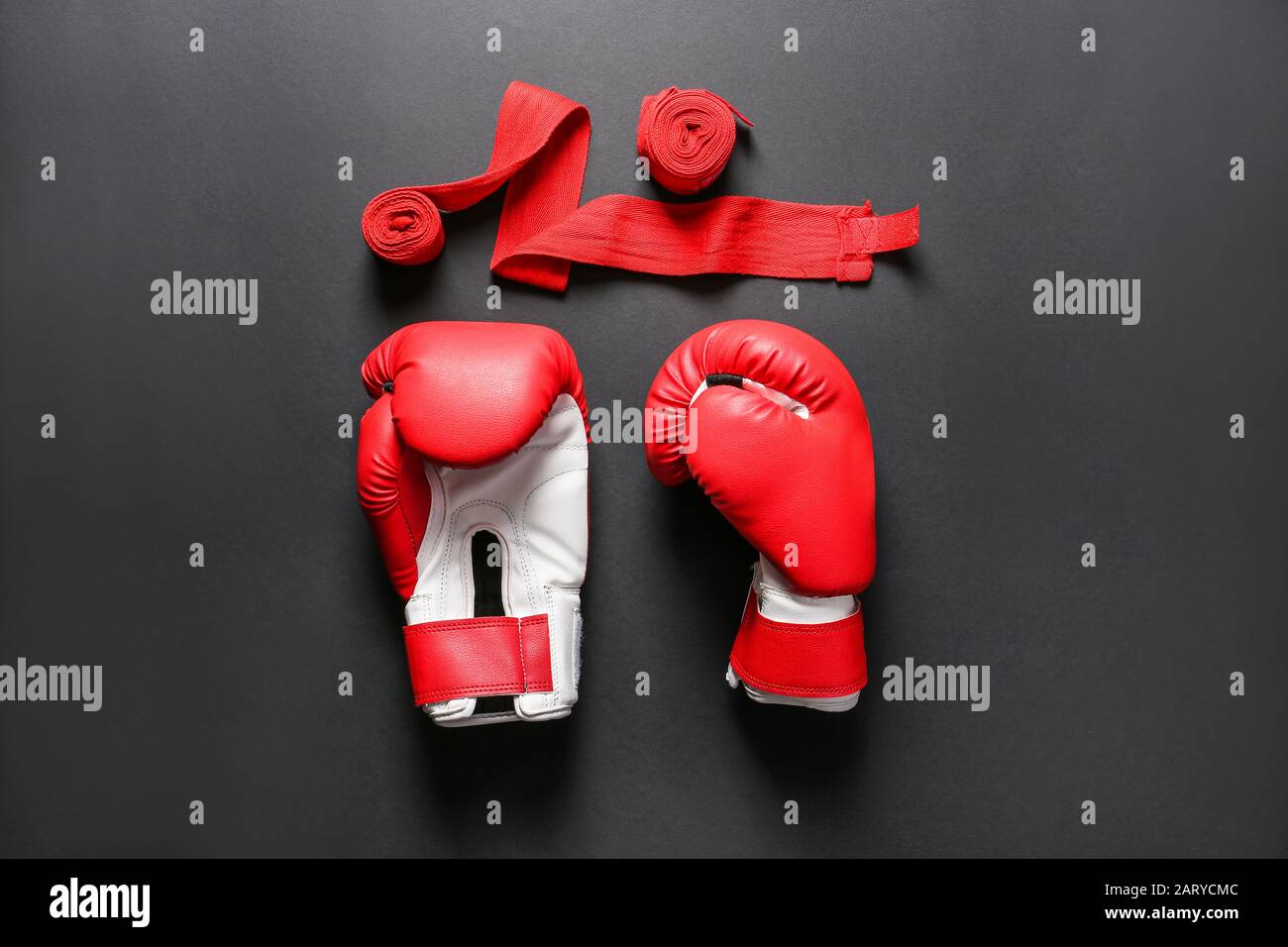 Boxhandschuhe und Handgelenkbänder auf dunklem Hintergrund Stockfoto