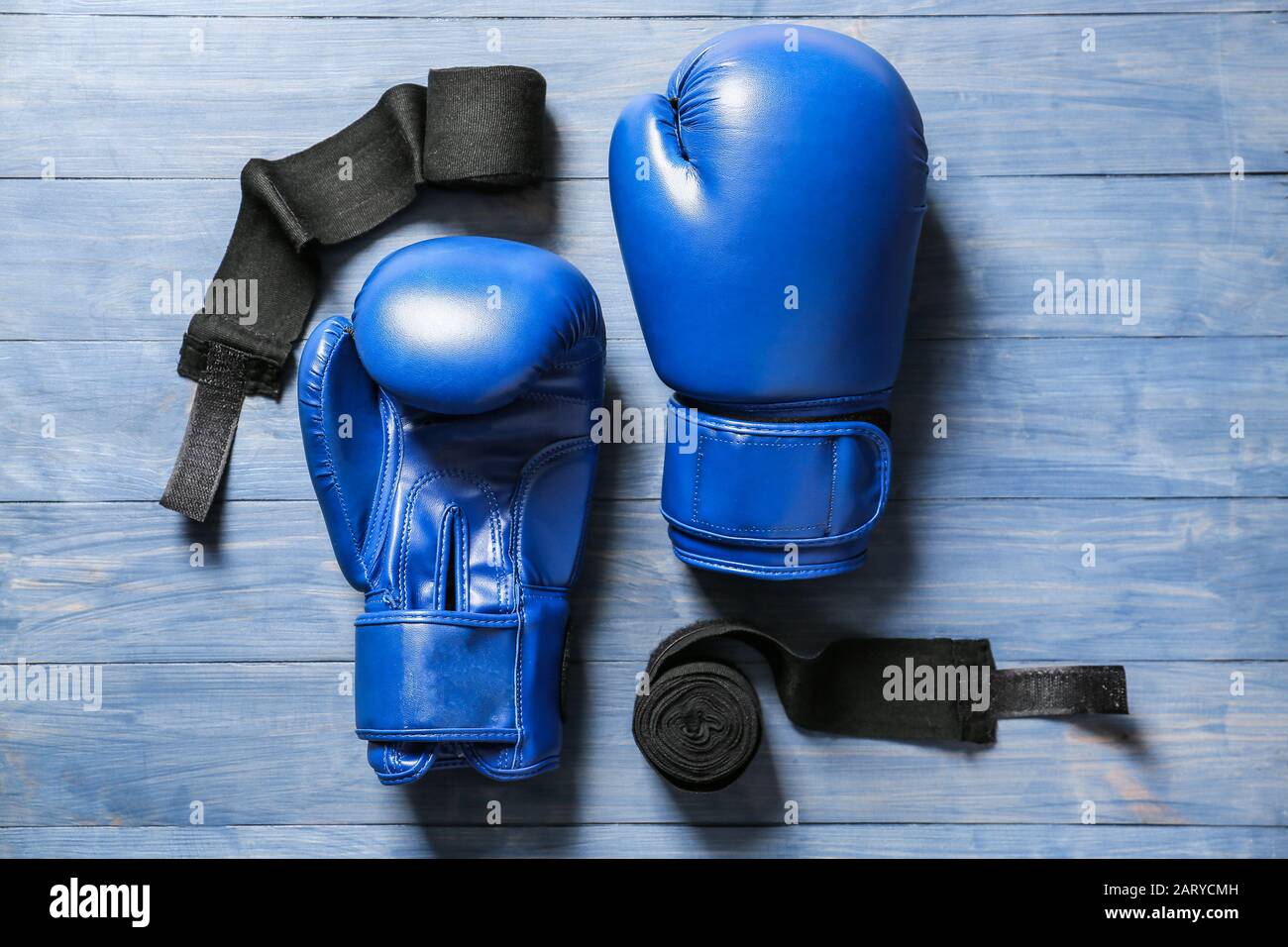 Boxhandschuhe und Armbänder auf Holzhintergrund Stockfoto