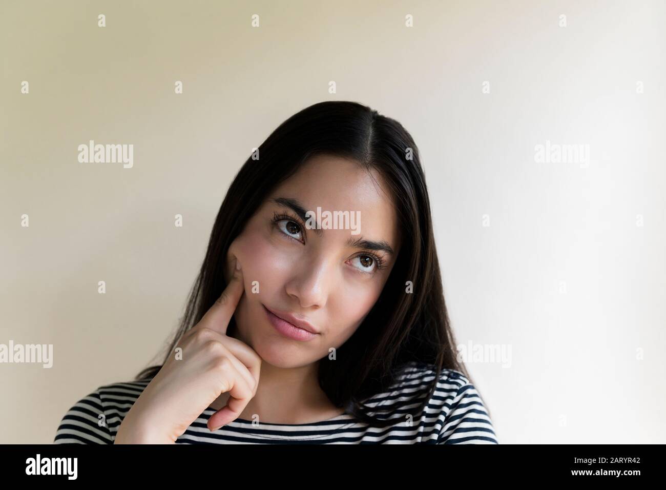 Gelangweilte Frau, die ihr Gesicht berührt Stockfoto