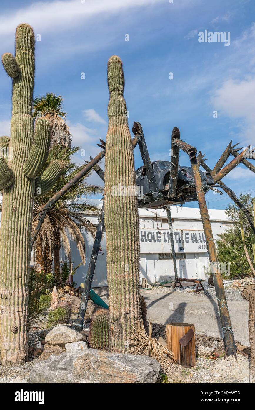 Eine gigantische Spinnenplastik aus geschweißten Teilen, darunter ein Volkswagen Käfer, steht außerhalb eines Geschäfts entlang der Indian Canyon Rd in Palm Springs. Stockfoto