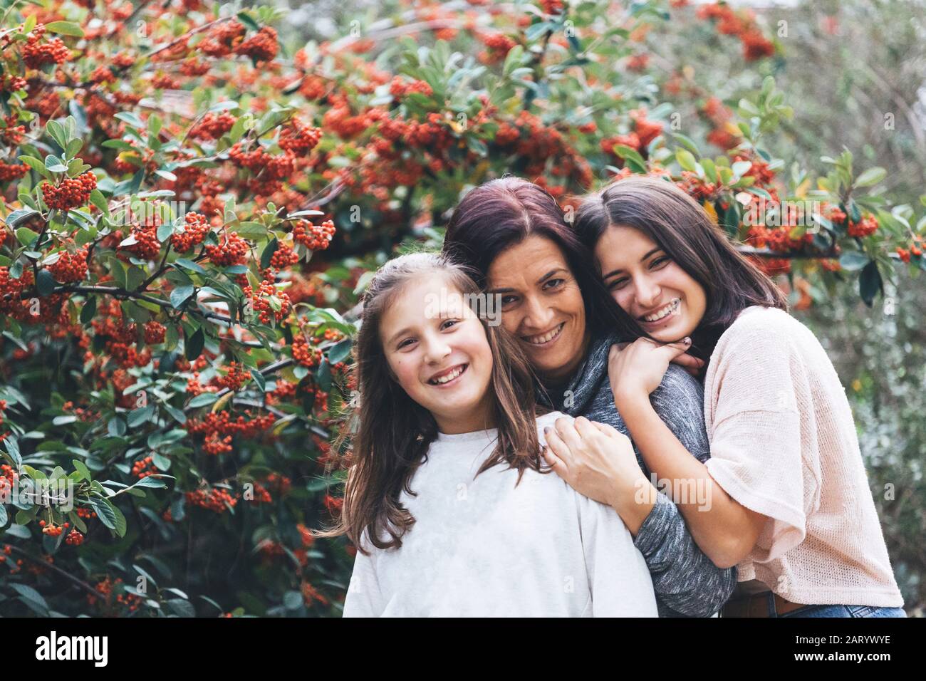 Mutter und Töchter lächeln und umarmen von Busch Stockfoto