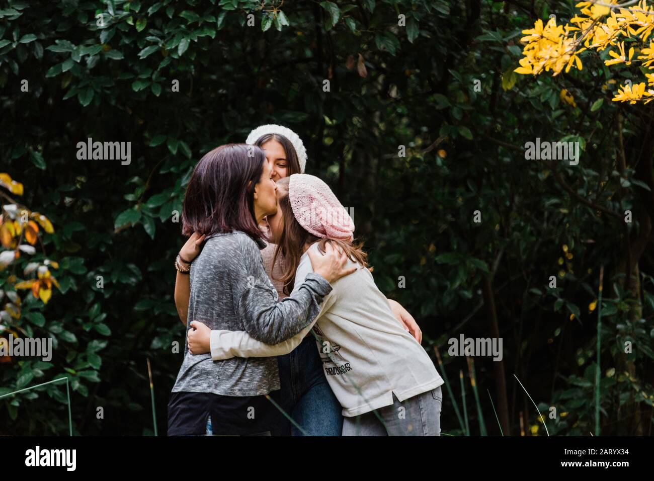 Mutter und Töchter umarmen von Bäumen Stockfoto