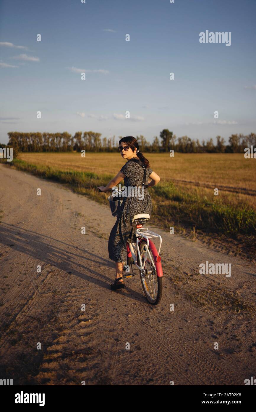 Frau Reiten Fahrrad auf Landstraße Stockfoto
