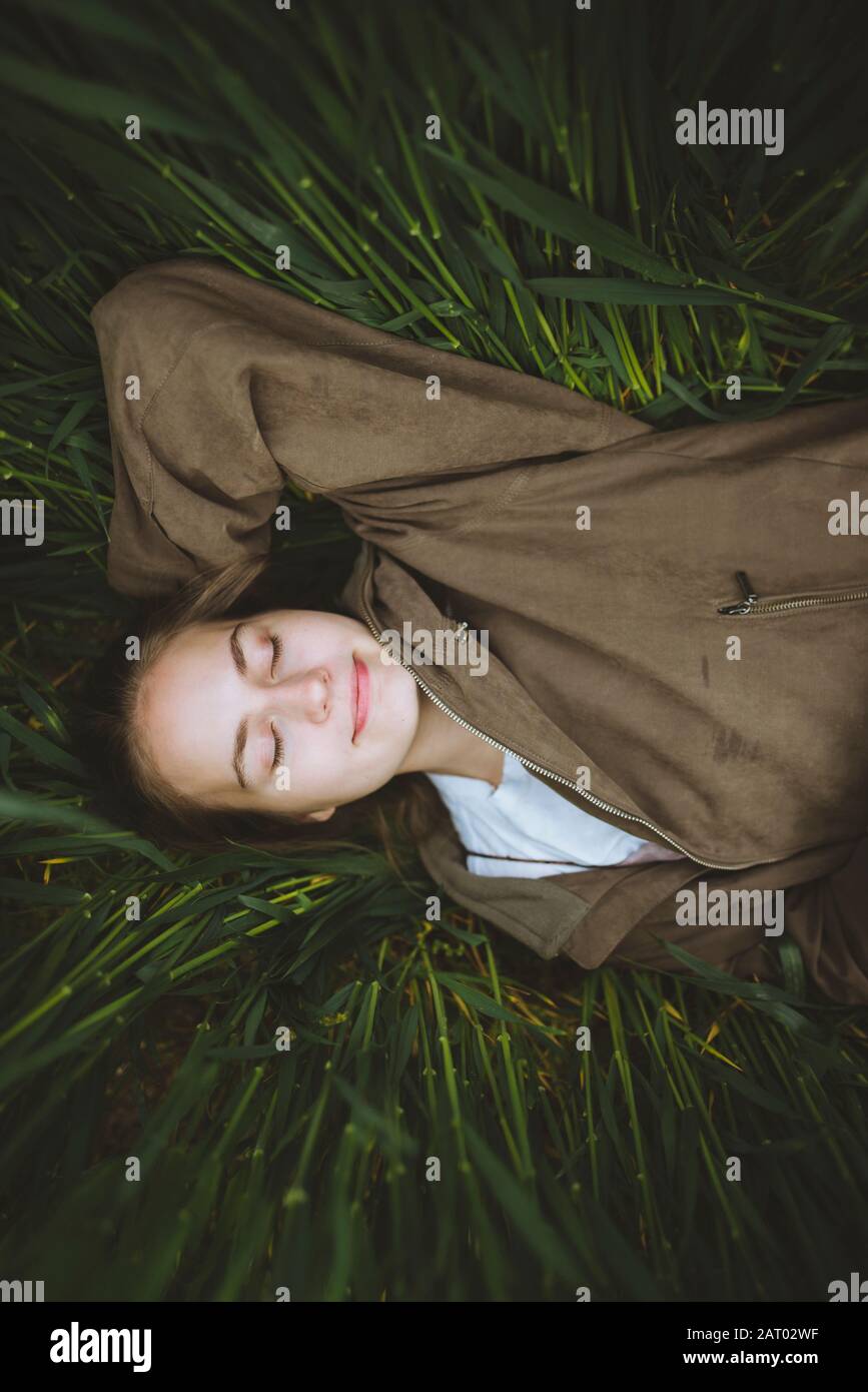 Lächelnde Frau im Gras liegend Stockfoto